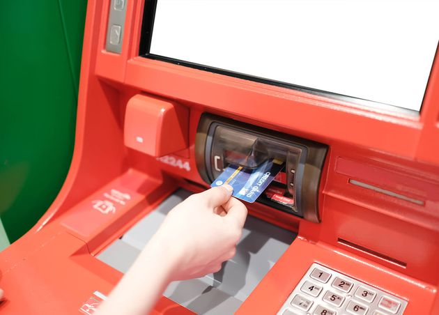 Frau verwendet Kreditkarte, um Geld am Geldautomaten abzuheben