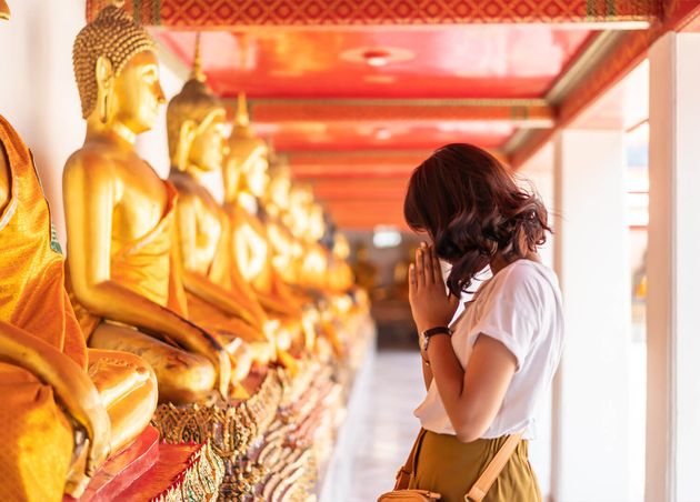 Happy Asian Woman Praying with Buddha