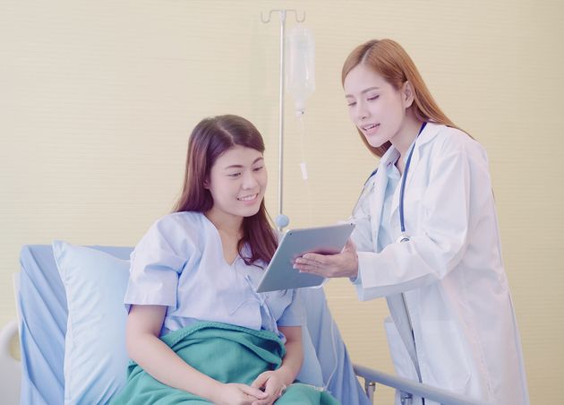 Beautiful Smart Asian Doctor Patient Discussing Explaining Something with Tablet
