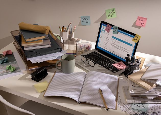 View Messy Office Workspace with Laptop