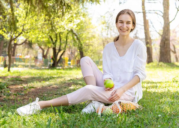 Woman Holding Apple Sitting Grass
