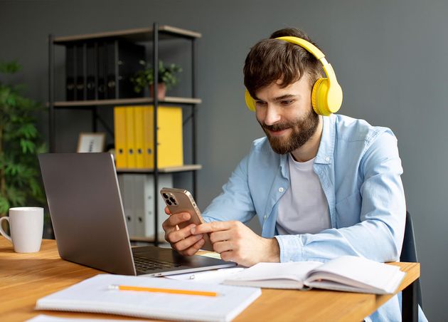 Young Man Listening Music Headphones while Working