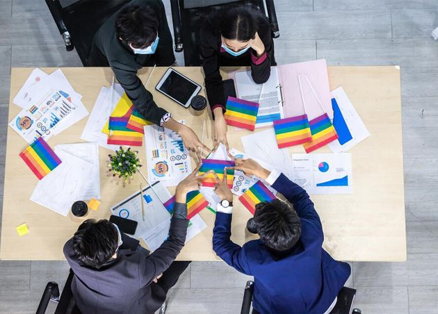 Top View Successful Workers Group Asian Business Partners Wearing Protective Mask Casual with Diverse Genders Lgbt Putting Their Hands Together with Paper Lgbt Flag It Meeting Room Office