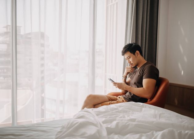 Man Looking His Mobile while Sitting Hotel Room