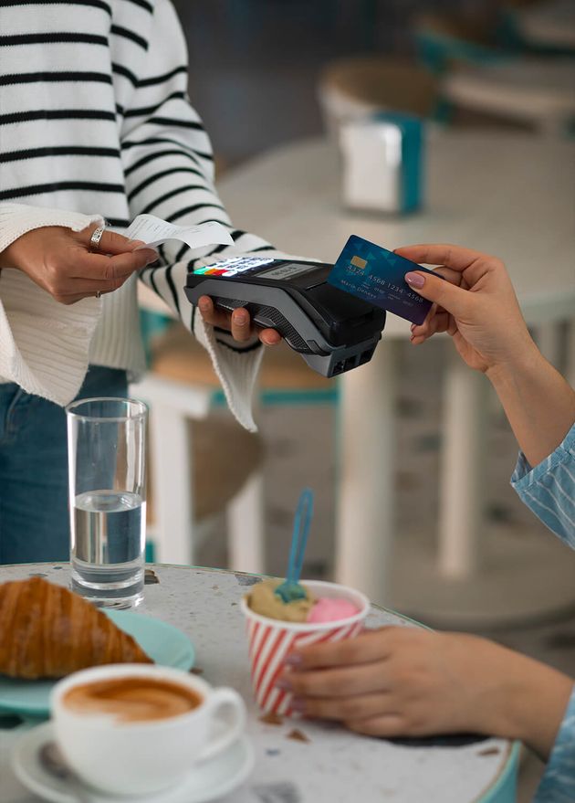 Person, die im Restaurant mit NFC-Technologie bezahlt