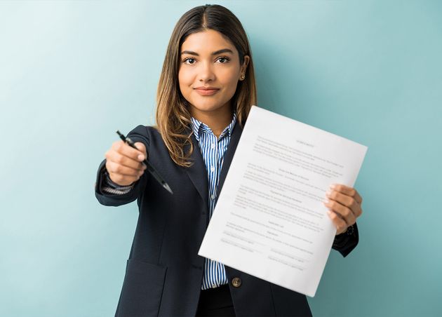 Confident Young Female Professional with Contract Pen against Colored Background
