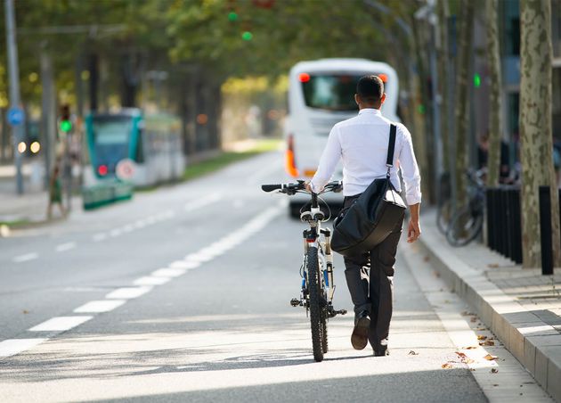 Businessman Walking with Bike Street after Work