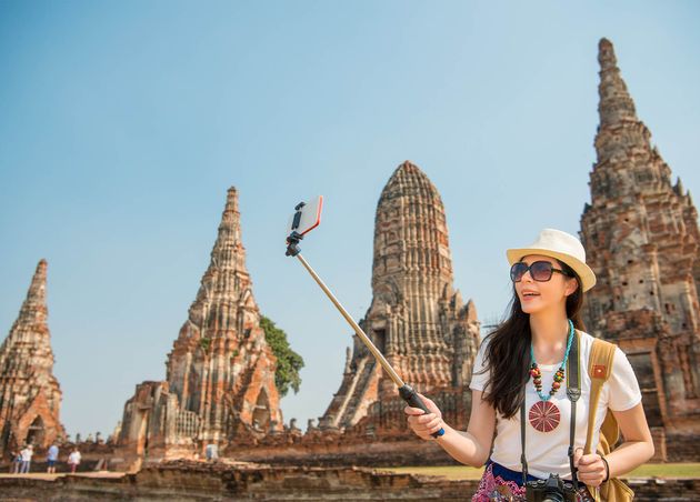 Thailand Ayutthaya Tourist Taking Picture Photo with Selfie Stick Smartphone Enjoying View Wat Chaiwatthanaram Stupa Travel Asia Summer Vacation