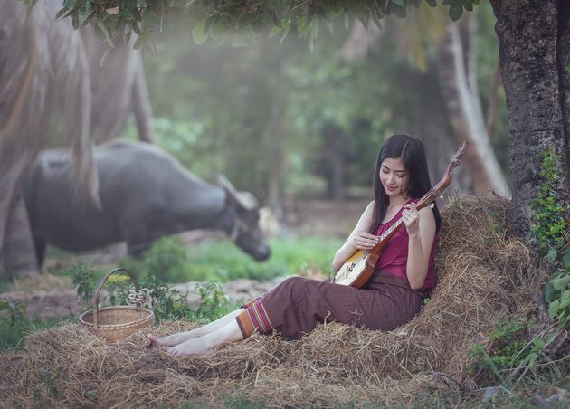 Thai Woman Playing Folk Song with Pin