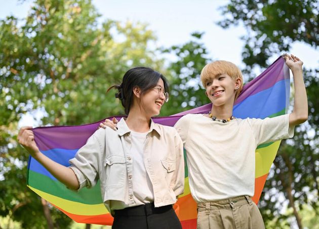 Happy Joyful Young Asian Girl Holding Lgbt Rainbow Flag with Her Gay Friend