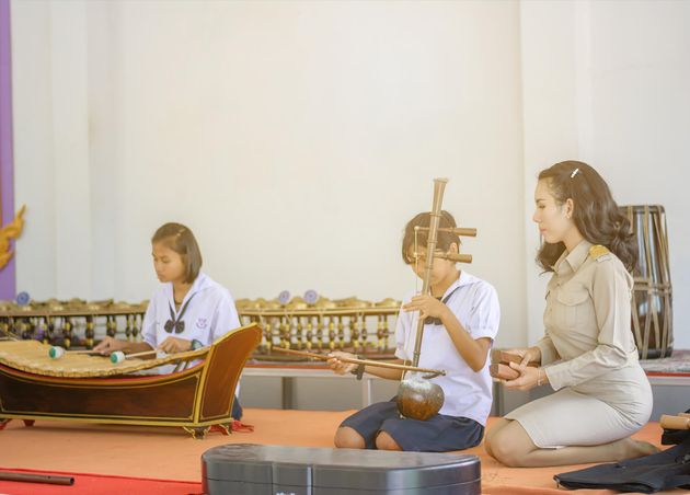 Beautiful Asian Teacher Teaching Students Practice Thai Instruments