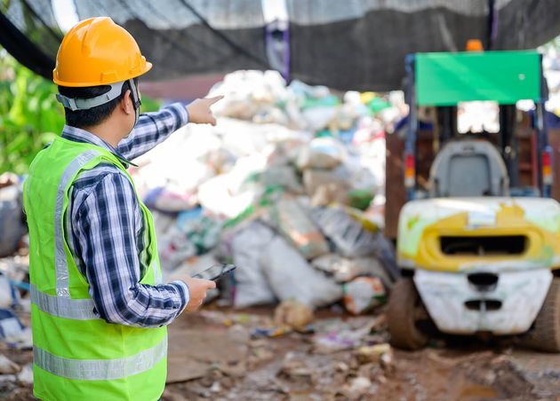 Male Worker Working Recycling Plant Holding Tablet Currently Overseeing Disposal Recycling Waste Small Waste Recycling Plant