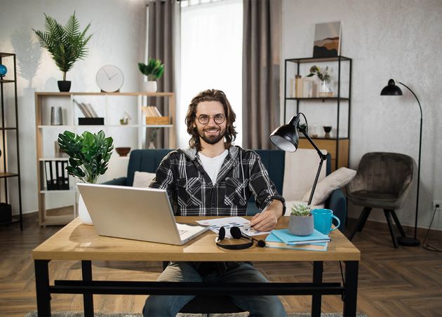 Bearded Young Man Checkered Shirt Eyeglasses Sitting Table with Modern Laptop