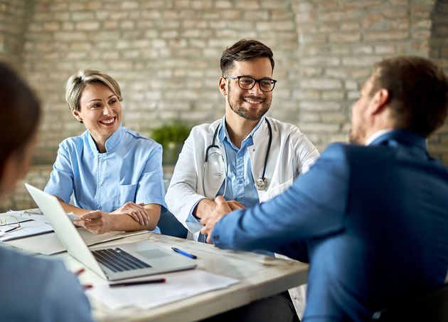Group Healthcare Workers Greeting Financial Advisor during Meeting Office Focus Is Young Doctor