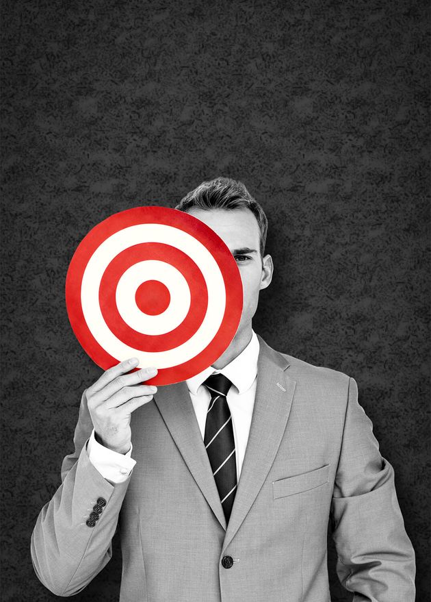 Businessman Holding Target against Grey Background