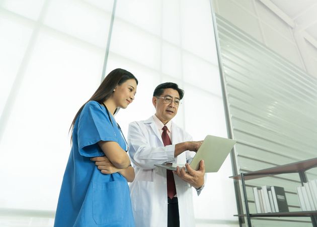 Two Asian Doctor Standing Use Laptop Notebook Computer Talking Discuss
