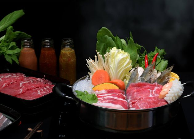 Close up View Shabu Shabu Hot Pot with Black Background Fresh Sliced Meat Sea Food Vegetables