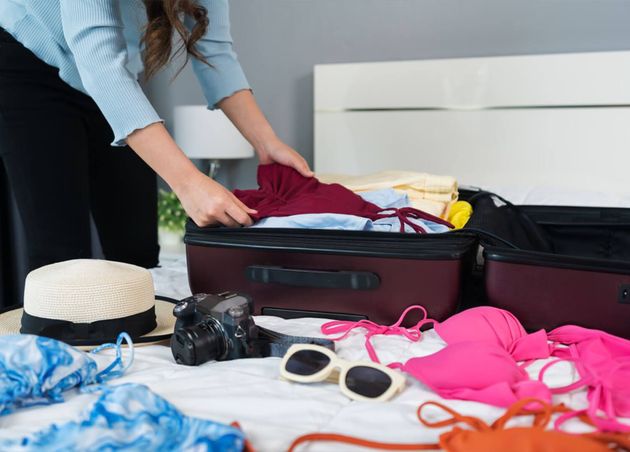 Woman Preparing Packing Clothes into Suitcase Bed Home Holiday Travel Concept