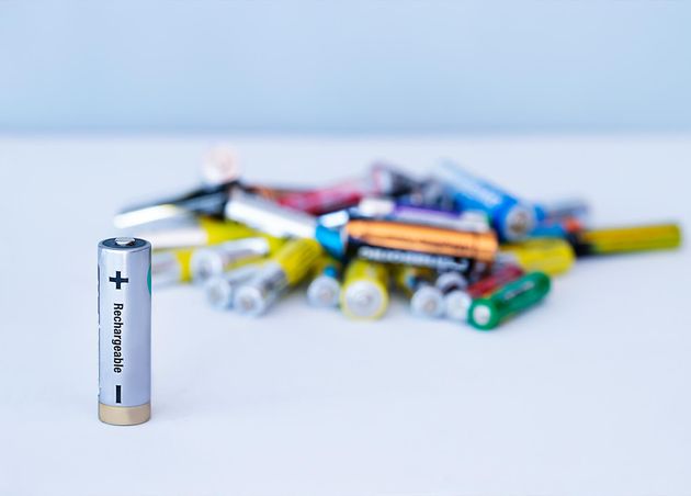 Nahaufnahme wiederaufladbarer Batterie mit Haufen wiederaufladbare Batterien unscharfer Hintergrund