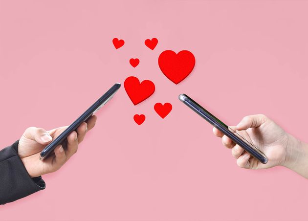 Couple Hands Holding Mobile Phone with Hearts