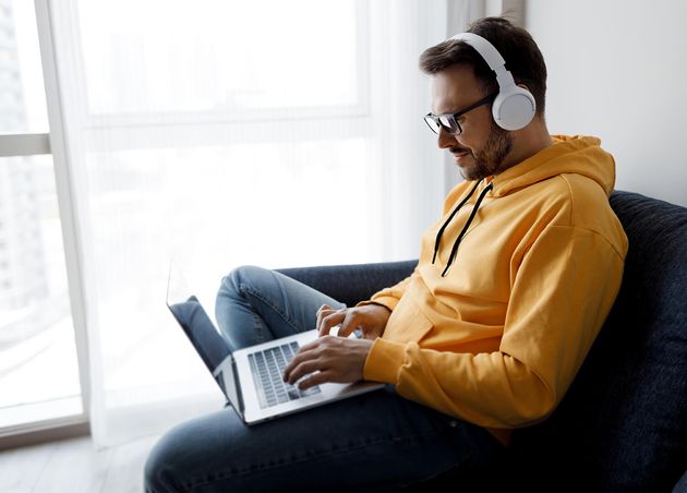 Handsome Man with Laptop Headphones Working Home