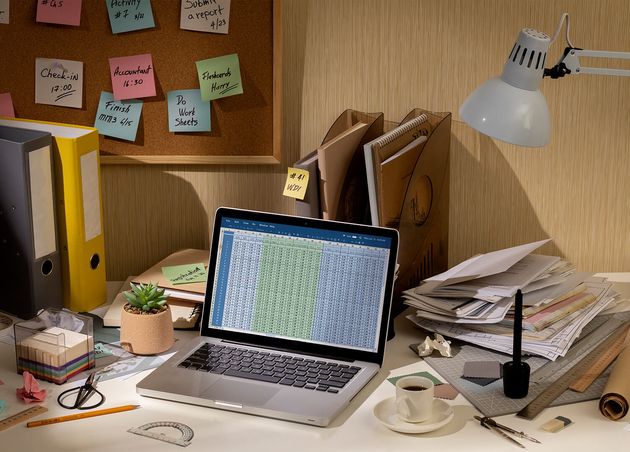 View Messy Office Workspace with Laptop Device