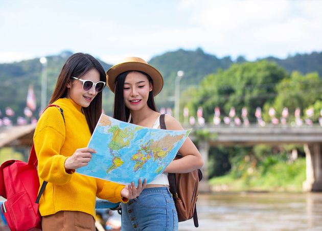 Two Female Tourists Hold Map Find Places