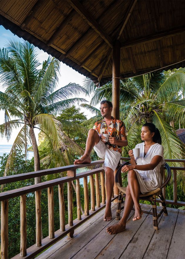 Couple Men Woman Balcony Beach Hut with Coffee Railay Beach Krabi Thailand Morning