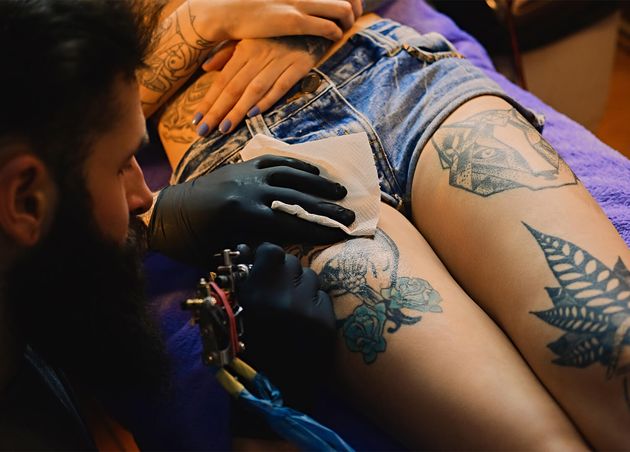 Close up Image Bearded Tattoo Male Artist Makes Tattoo Female Leg