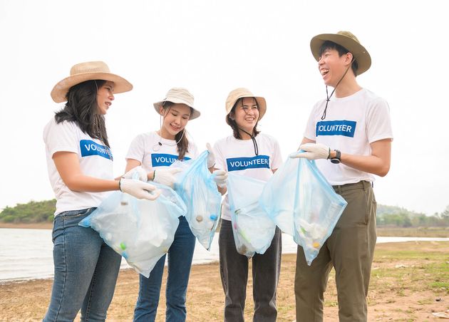 Volunteers from Asian Youth Community Using Rubbish Bags Cleaning up Nature Par