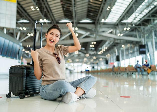 Lockdown Is Time Travelhappiness Asian Femlae Traveller Wear Casual Cloth Hand Wave Gesture Smiling while Sit Relax Terminal Airport Floor with Luggage Safety Travel Concept