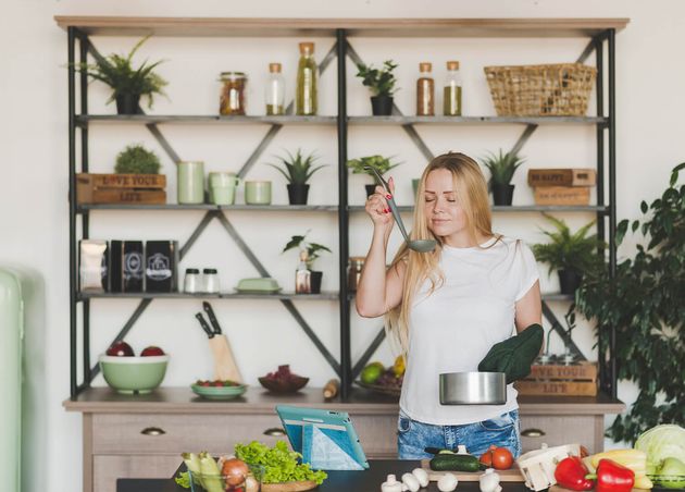 Blonde Young Woman Smelling Soup from Ladle Kitchen