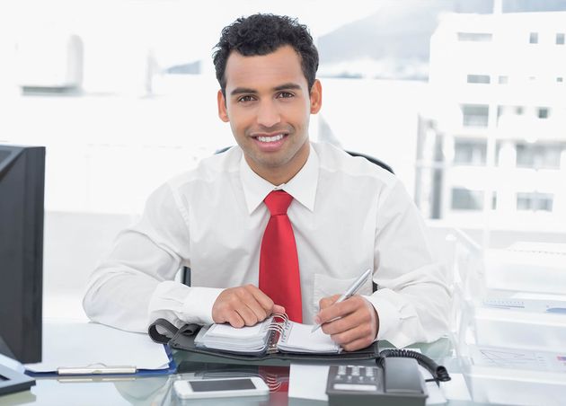 Smiling Young Businessman Writing Diary Office