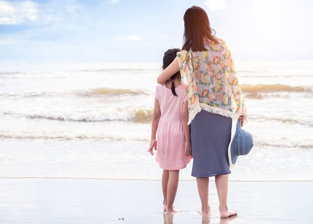 Asian Mother Hugging Daughter Beach