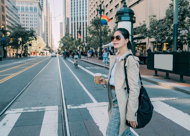 Schöne sorglose asiatische Frau, die mit Pappbechergetränk Stadtverkehr San Francisco USA elegantes städtisches Mädchen mit Sonnenbrille-Tasche
