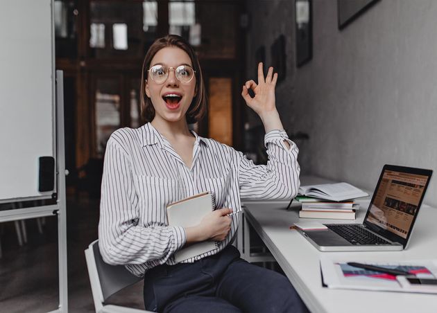 Joyful Girl Office Worker Shows Ok Sign Portrait Woman Pants Light Blouse Workplace