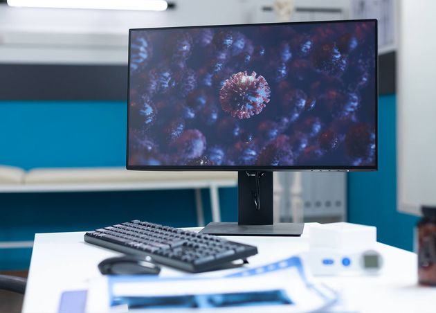 Empty Hospital Office with Computer Standing Table Having Virus Cell Screen Coronavirus Global Pandemic Examination Room Equipped with Professional Tools Medicine Concept