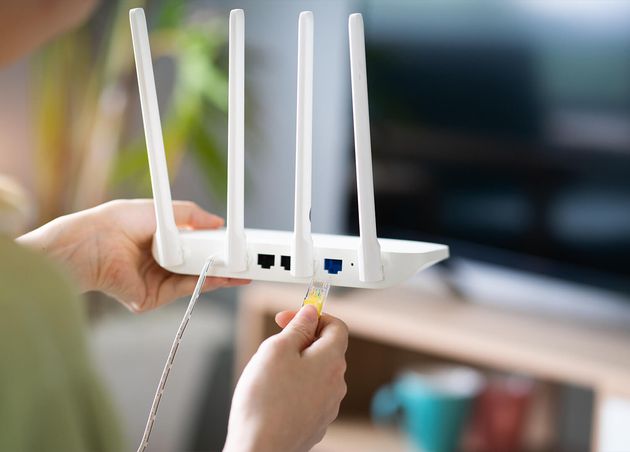 Asian Girl Is Plugging Network Cable into Wifi Transmitter