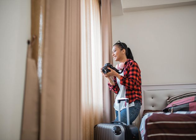 Local Female Tourist Capturing Scenery with Camera through Window from inside Hotel