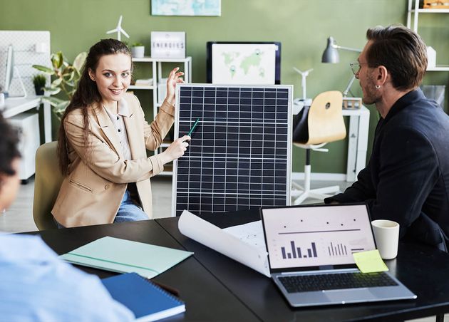 Young Woman Presenting Solar Panel Her Colleagues during Business Meeting Office