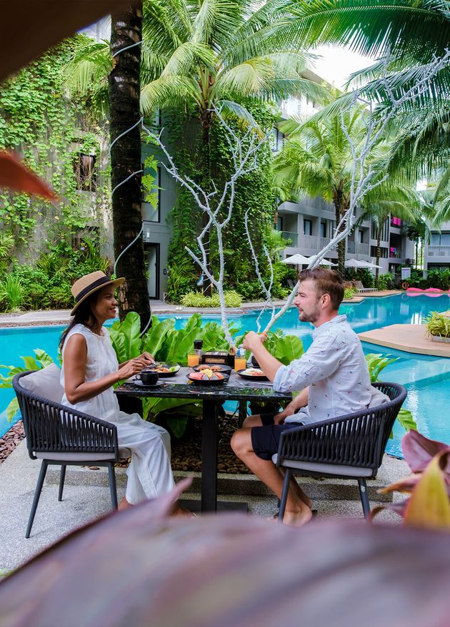 Couple Having Breakfast by Pool during Vacation