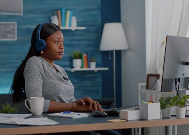 Student with Black Skin Having Headphone Puts Listening Online Univeristy Course Using Elearning Platform Sitting Desk Living Room