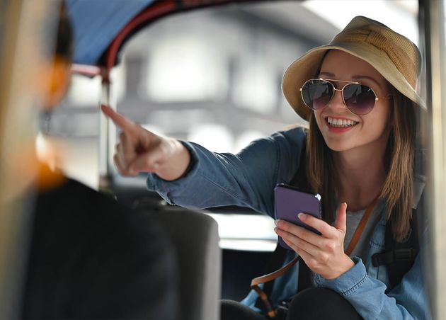Smiling Woman Traveler Using Smartphone Helping Tourism about Travel Map while Sitting Tuk Tuk Public Transport Thailand