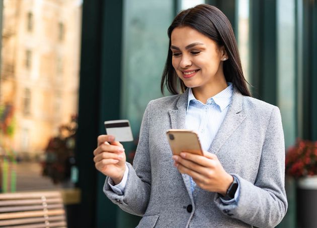 Smiley Businesswoman Using Smartphone Credit Card Outdoors
