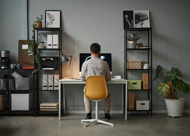 Weitwinkelaufnahme Mann verwendet Computer zu Hause mit moderner Tech-Inneneinrichtung Copy-Space