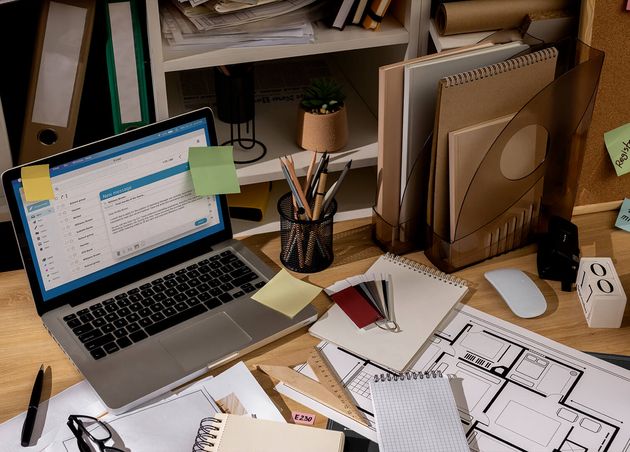 View Office Desk with Messy Workspace Laptop