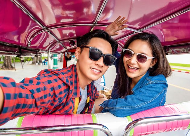 Cheerful Young Asian Couple Tourists Taking Selfie while Traveling Local Colorful Tuk Tuk Taxi Exploring Bangkok City Thailand