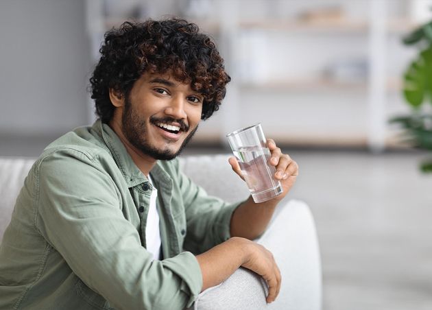 Darkskinned Man Drinking Water Smiling Home Interior